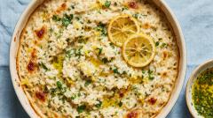 A serving of creamy lemon and herb baked risotto in a shallow bowl.