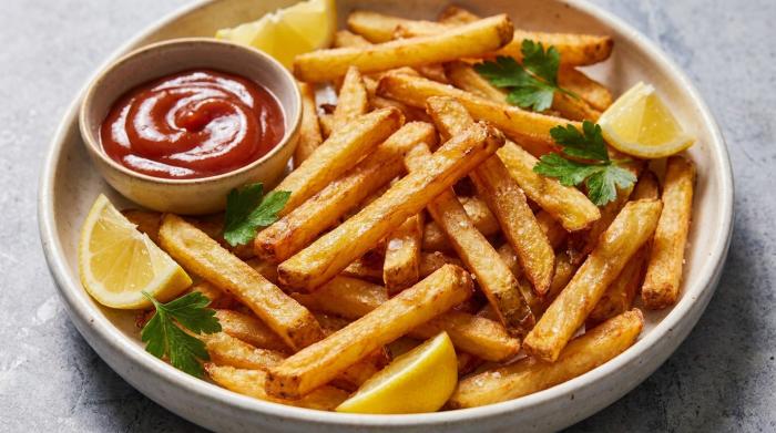 A pile of golden, crispy french fries in a serving bowl.