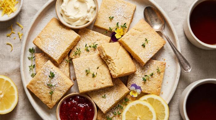A stack of tender, pale golden shortbread cookies on a plate.