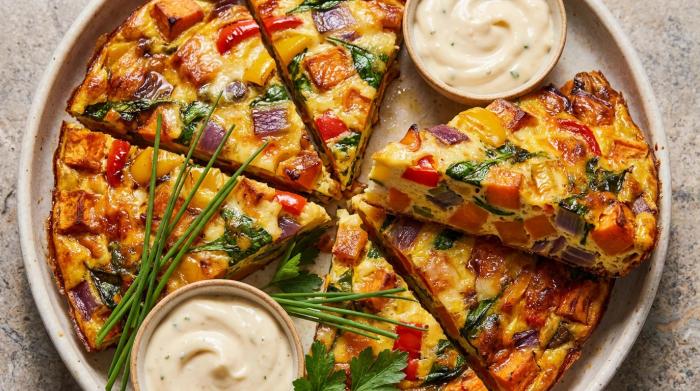 A golden baked vegetable frittata topped with browned mushrooms and feta cheese.