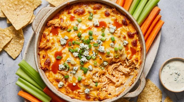 A corn chip scooping up hot, cheesy buffalo chicken dip.