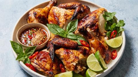 Close up of caramelized Thai grilled chicken with bronzed edges.