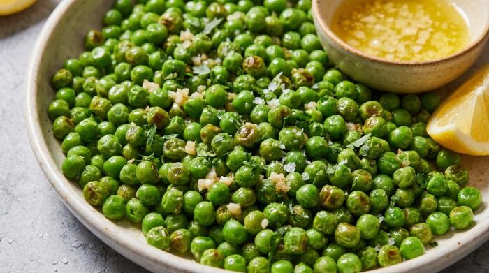 A close-up of glossy garlic buttered peas in a bowl