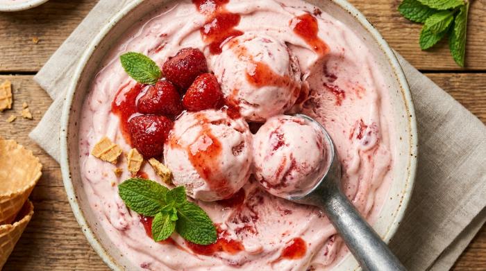 Perfectly scooped homemade strawberry ice cream in a cone.
