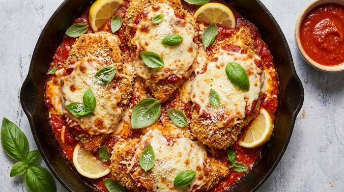 Baked chicken parmigiana with melted mozzarella and fresh basil