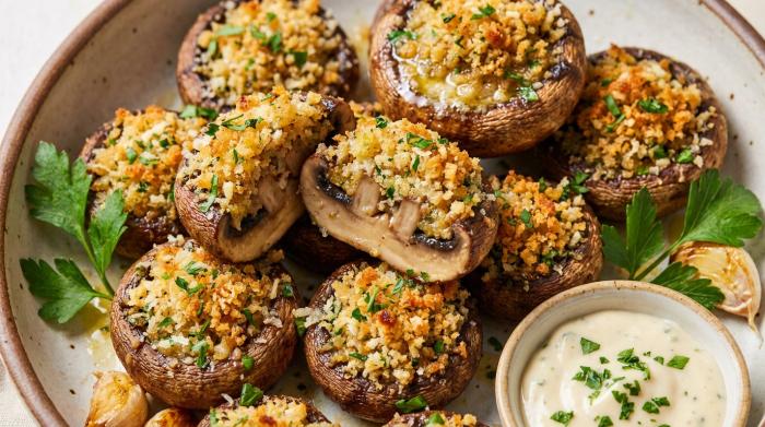 Close-up of golden-brown stuffed mushrooms on a serving platter.