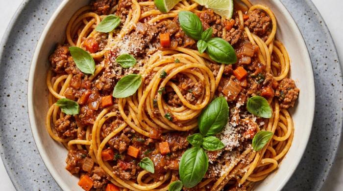 Finished one pot pasta bolognese in a serving bowl with parmesan garnish.