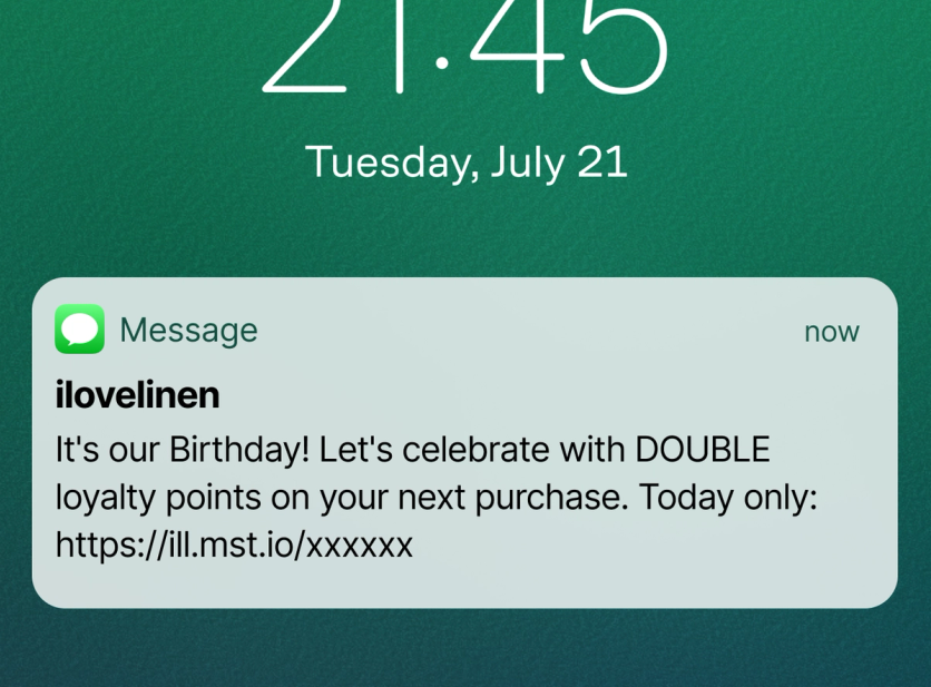 SMS notification on a phone lock screen: I Love Linen birthday message offering double loyalty points today only