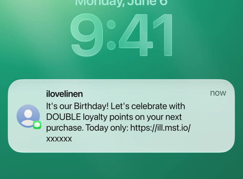 SMS notification on a phone lock screen: I Love Linen birthday message offering double loyalty points today only