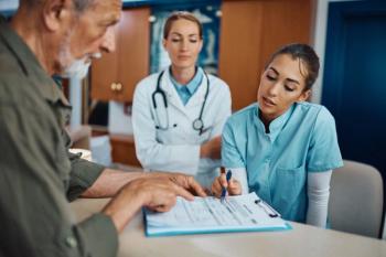 Young nurse assisting senior man to fill out medical documents | Image Credit © Drazen - stock.adobe.com