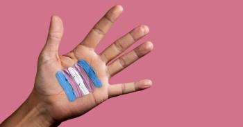 trans flag paint on hand | Image credit: Nito - stock.adobe.com.