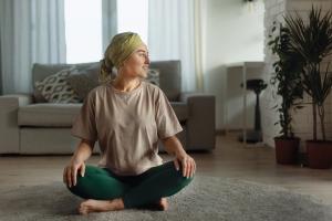 Cancer survivor practicing yoga in apartment | Image credit: Halfpoint - stock.adobe.com