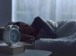 Woman sleeping next to alarm clock - stokkete - stock.adobe.com