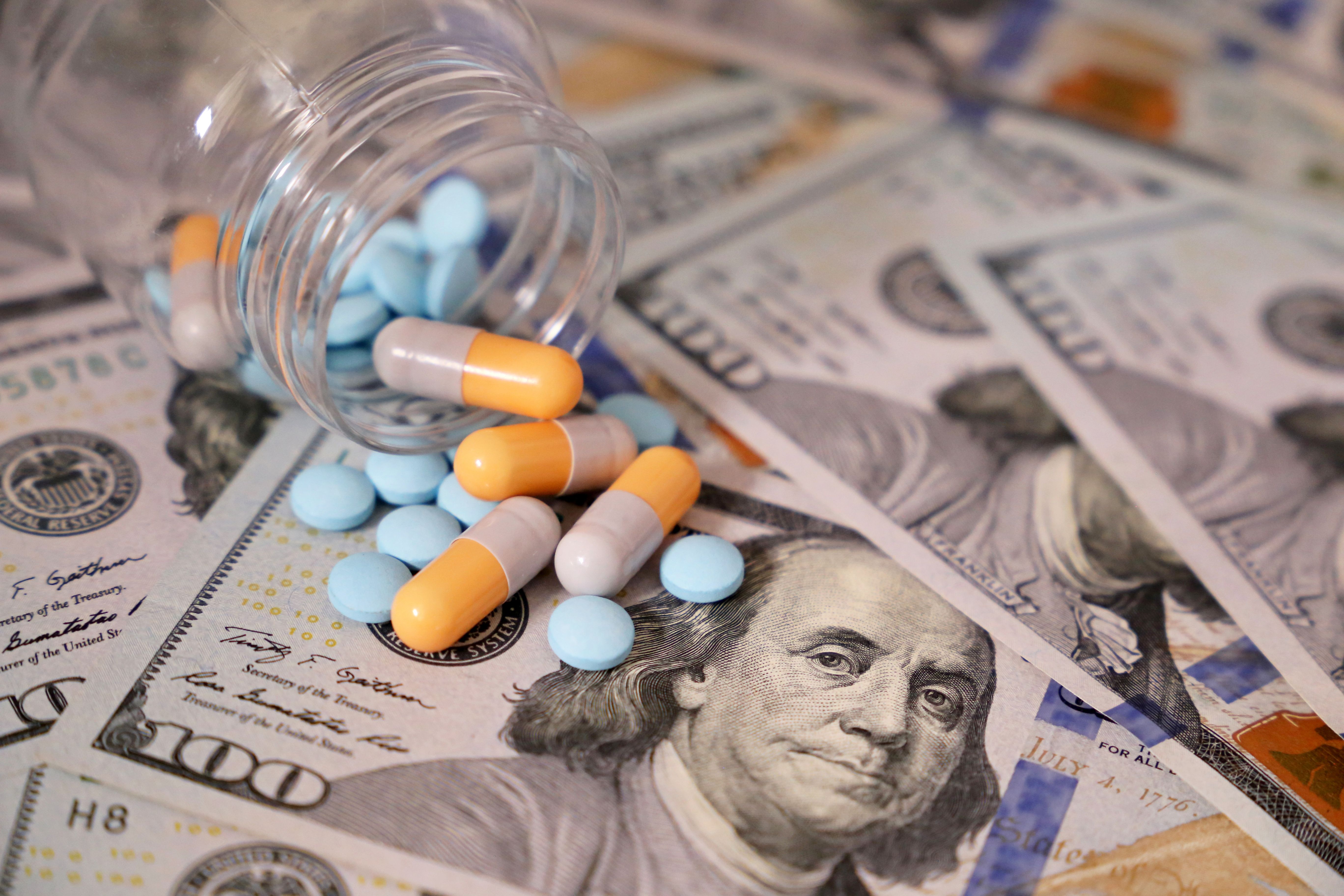 Pills spilled on $100 bills | Image Credit: Oleg - stock.adobe.com