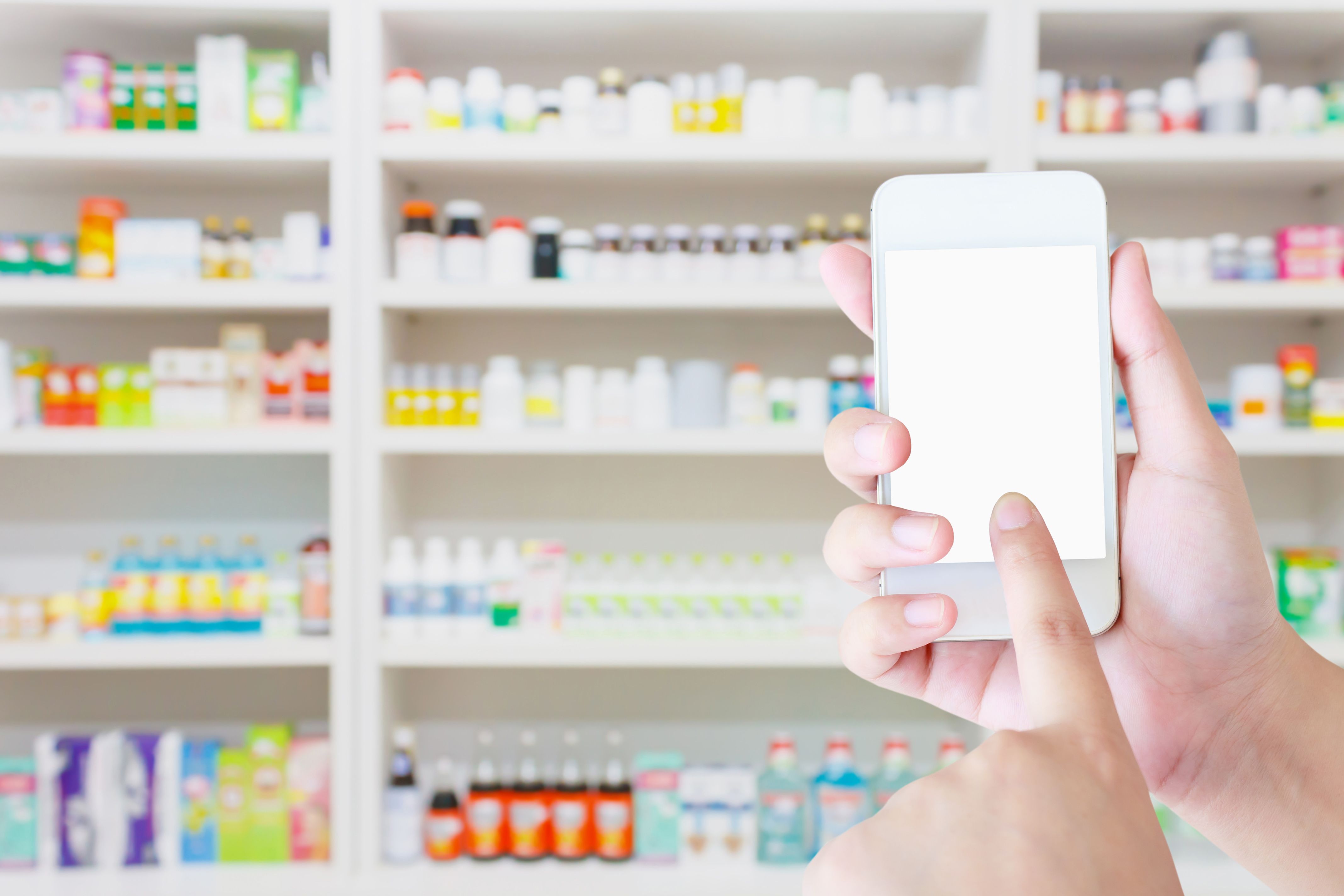 person holding smartphone in front of medicine cabinet