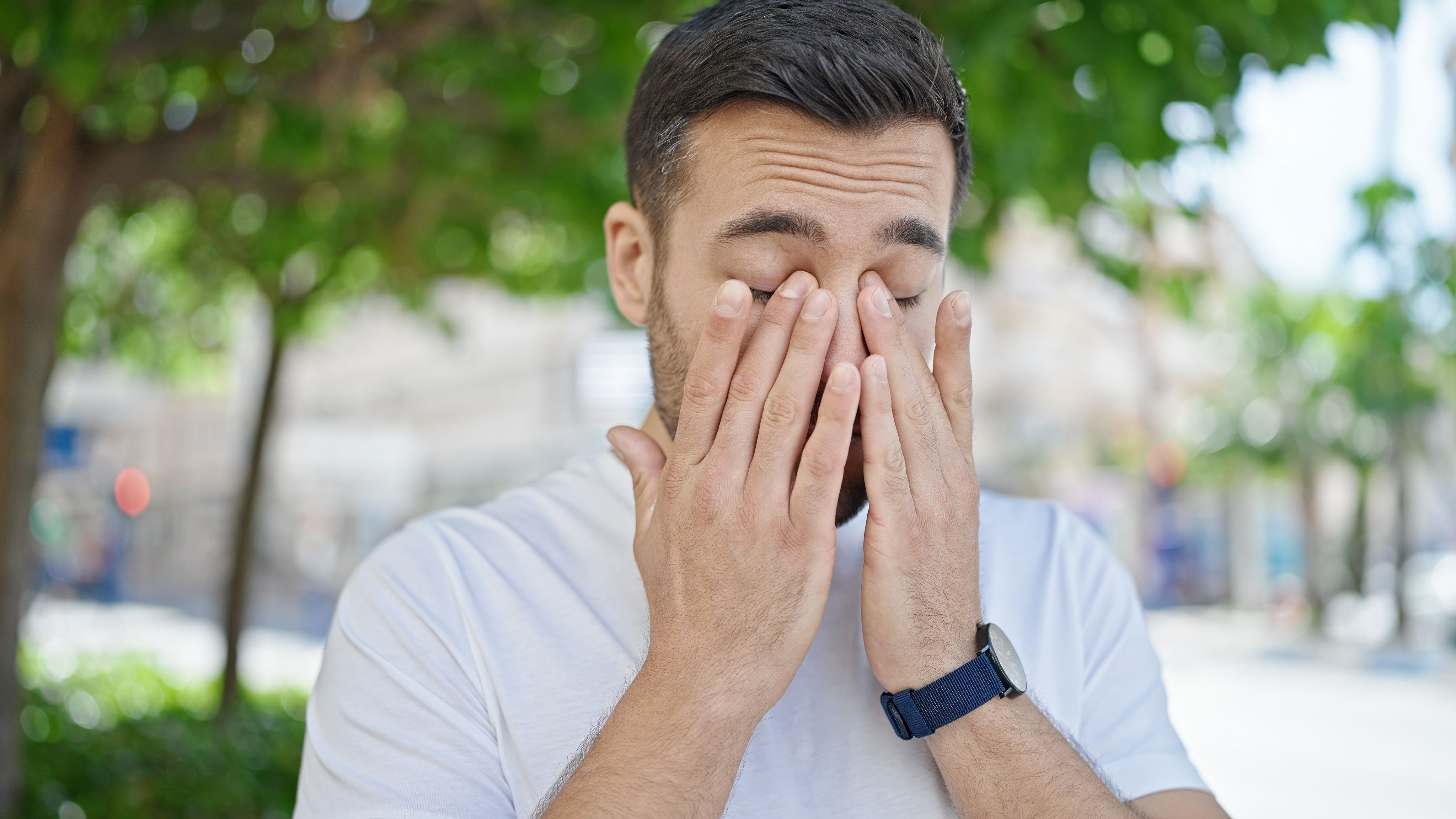 Young hispanic man standing with serious expression rubbing eyes at street | Image credit: Krakenimages.com - stock.adobe.com