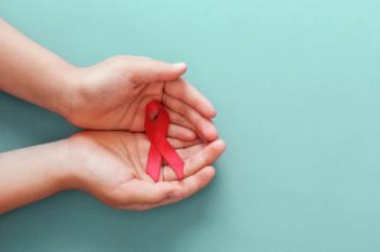 Hands holding red ribbon for HIV Awareness | Image credit: SewcreamStudio - stock.adobe.com