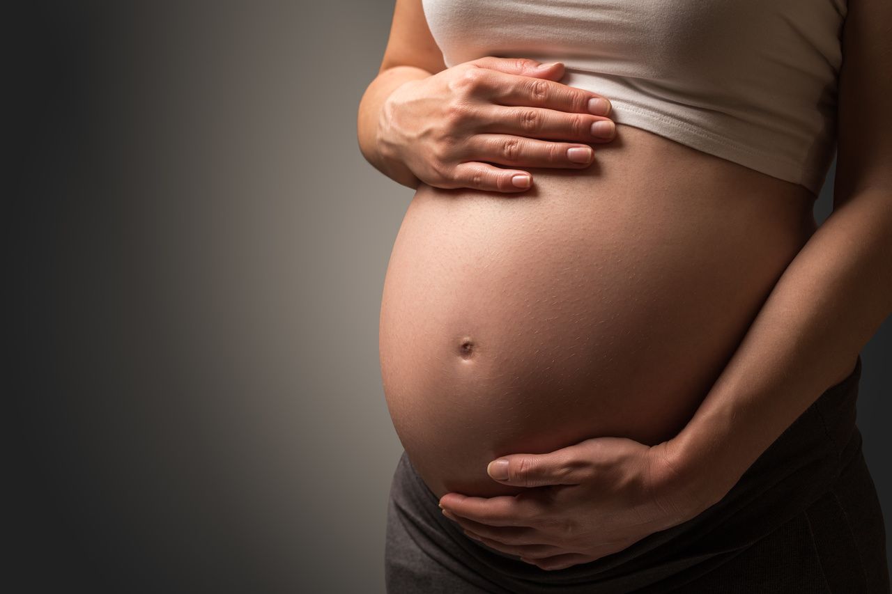 pregnant woman holding stomach