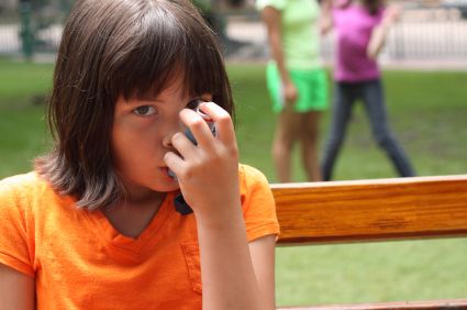 Young girl using an asthma inhaler