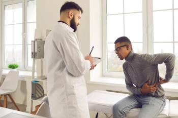 Patient telling physician about his pain and health problems during visit to hospital. Young African-American man complaining about back ache while sitting on examination bed at the doctor's - Studio Romantic - stock.adobe.com.jpeg