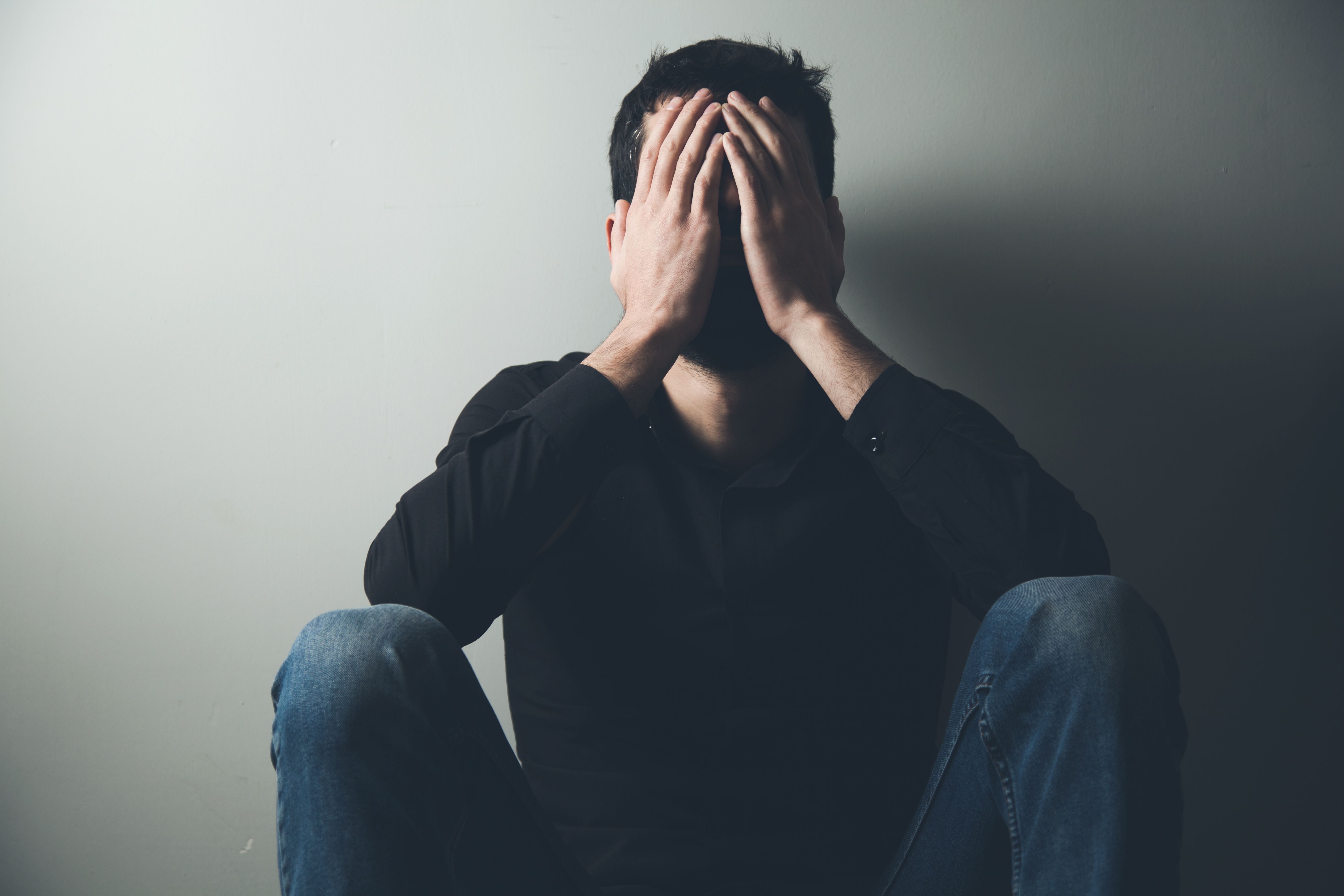 Man sitting with head in hands | Image credit: ARAMYAN - stock.adobe.com