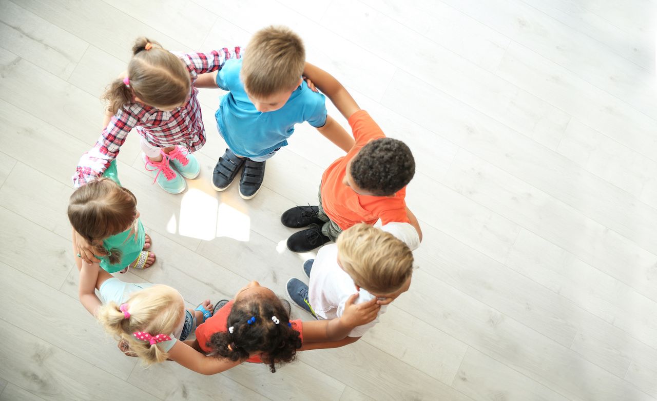 Little children making circle with hands around each other indoors, top view. Unity concept: © New Africa - stock.adobe.com