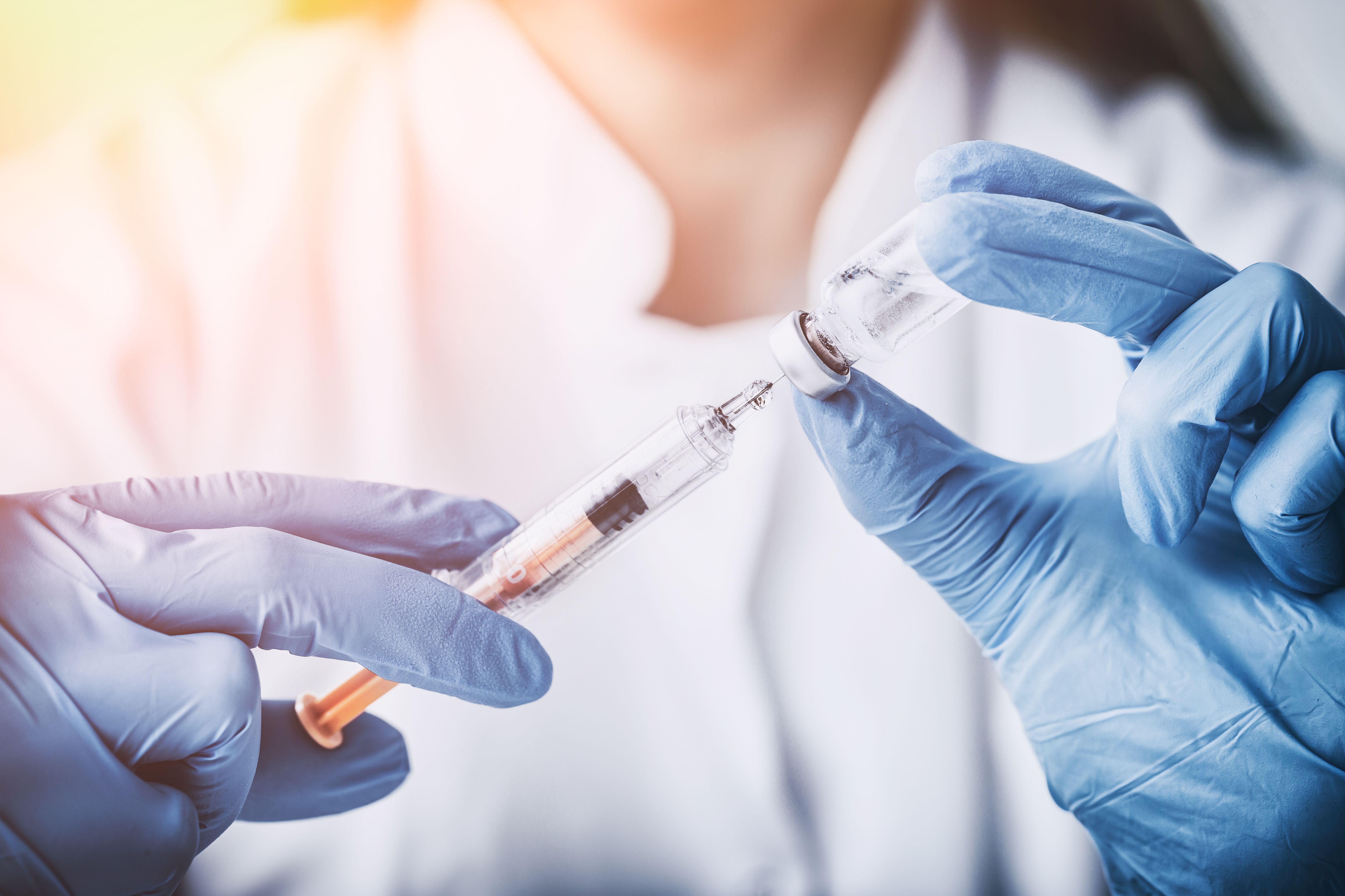 scientist filling syringe from a vial