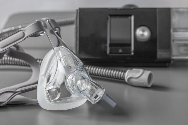 Sleep apnea CPAP mask on the grey table - sokko_natalia - stock.adobe.com