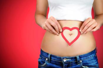 Mother holding heart over pregnant belly