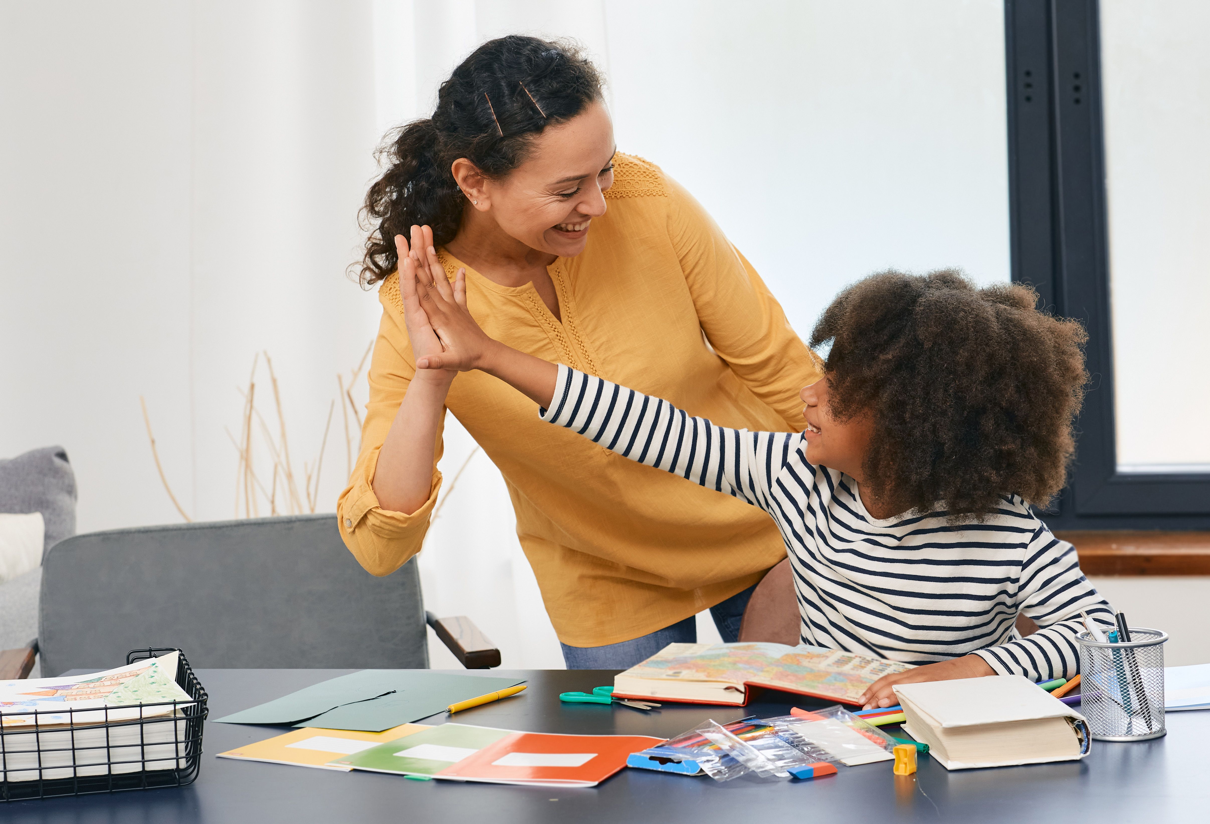 Child and therapist high-fiving | Image credit: Peakstock – stock.adobe.com