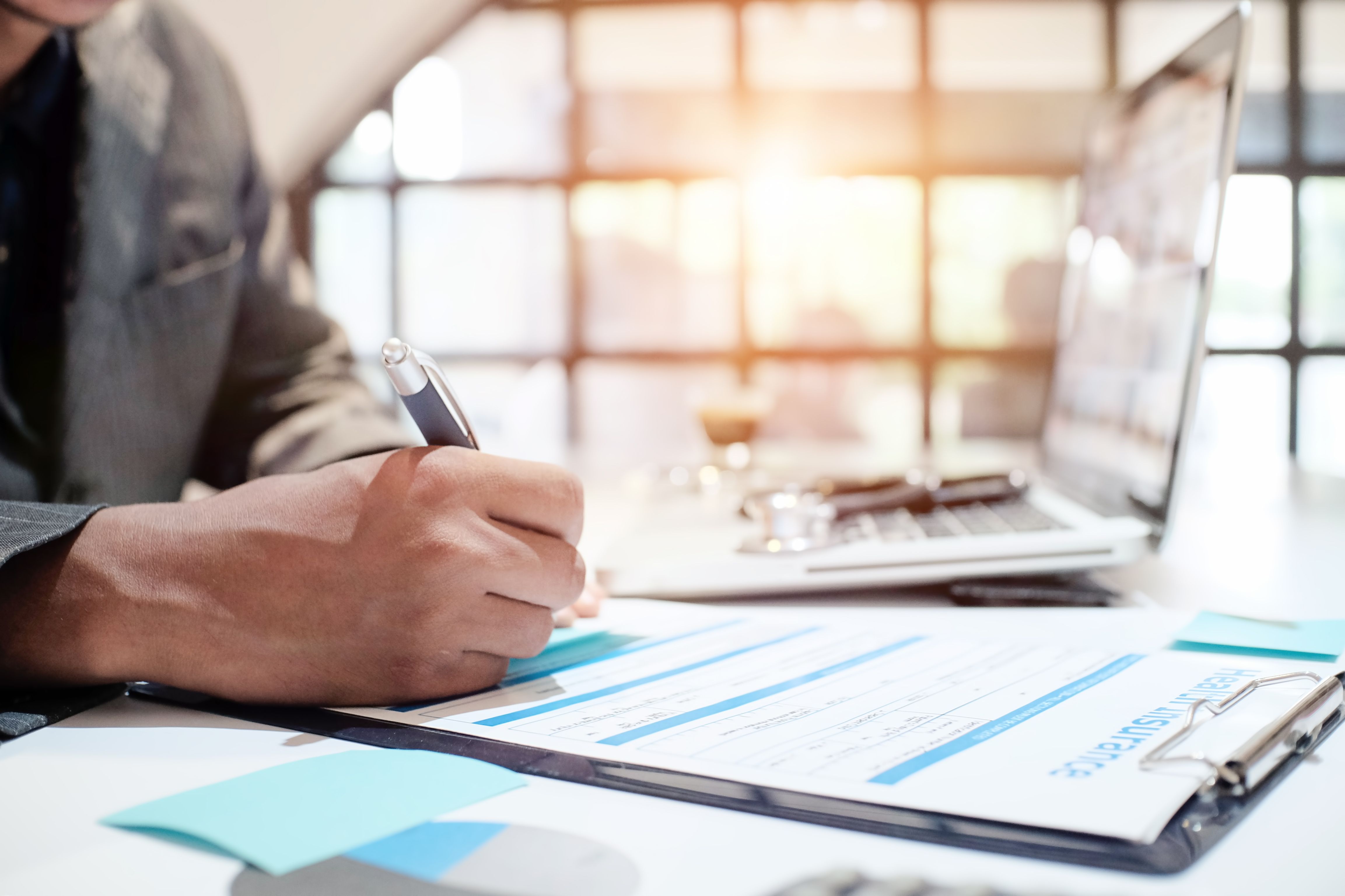 Person filling out insurance paperwork | Image credit: sodawhiskey - stock.adobe.com