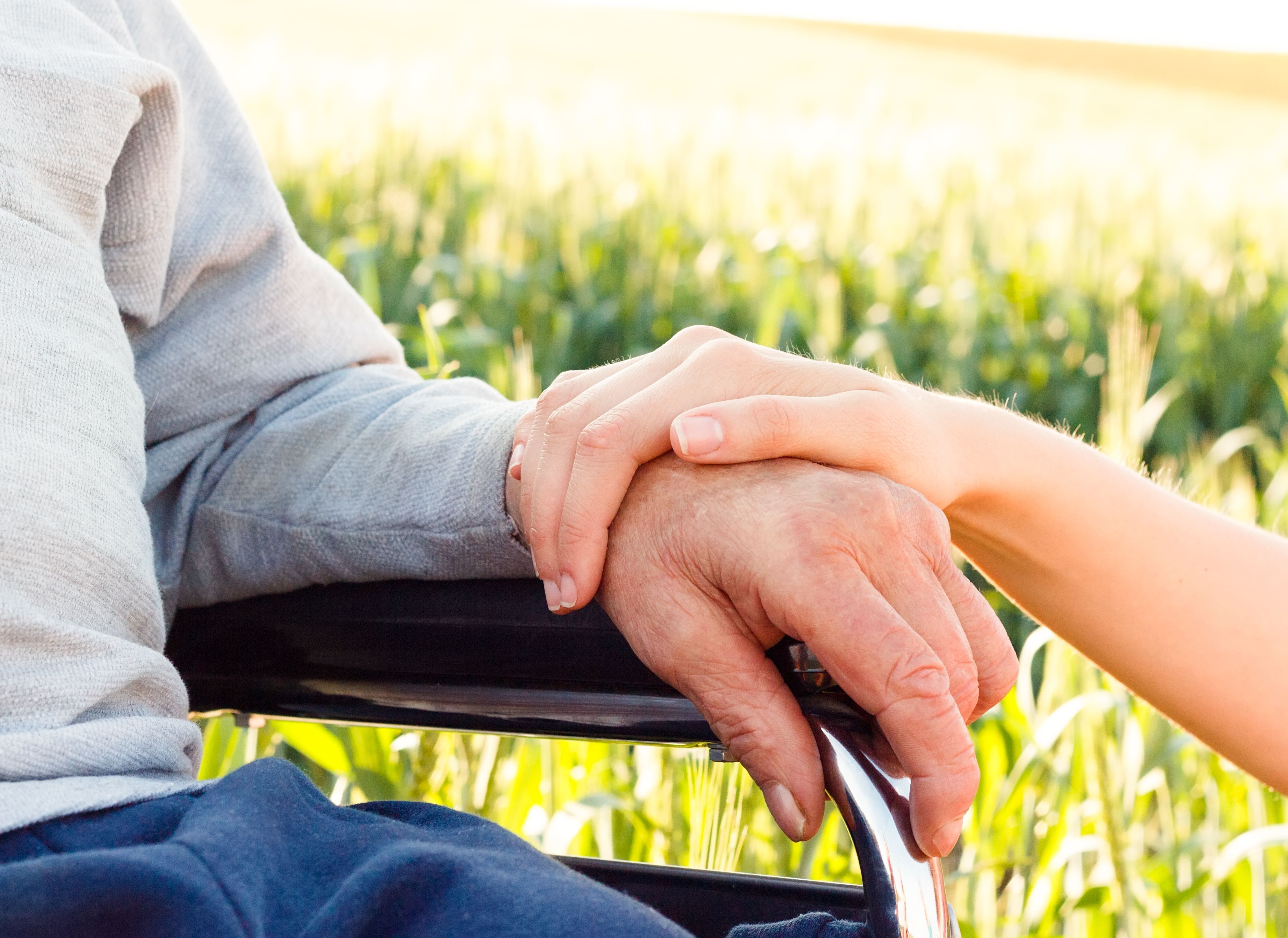 younger person holding hands with older person