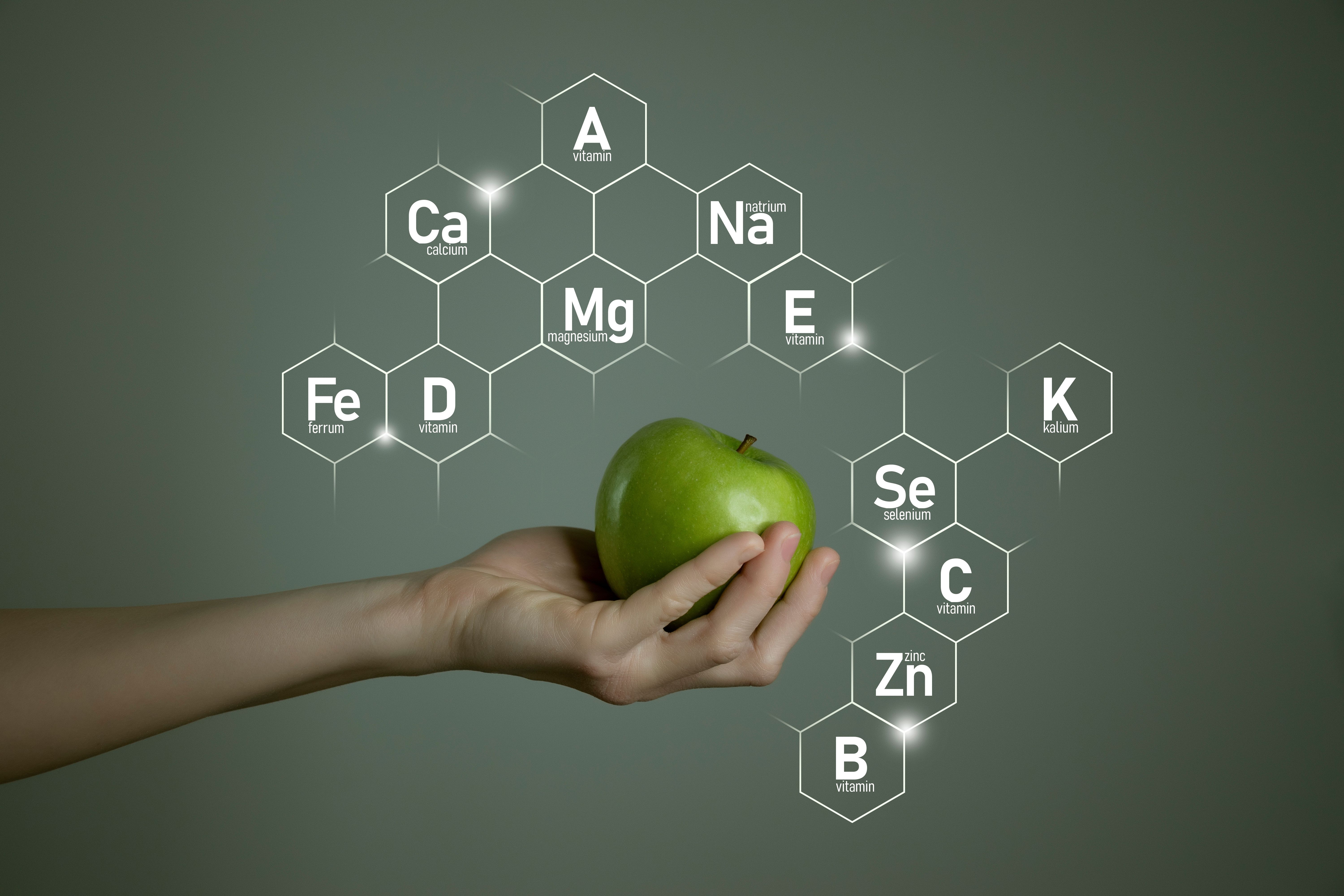 Hand holding green apple surrounded by micronutrient names | Image credit: mi_viri – stock.adobe.com