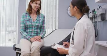 doctor talking to patient sitting on an exam table