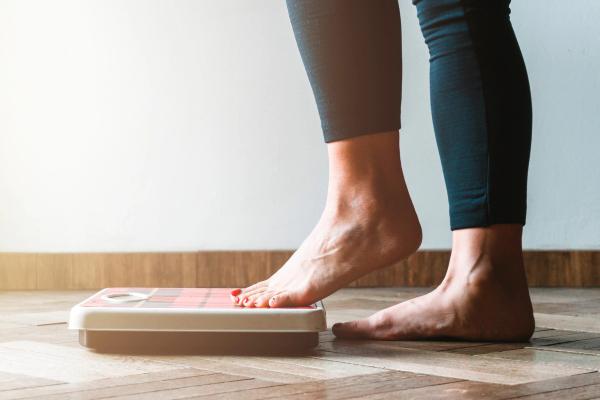 Woman stepping on scale | Image credit: Hunterframe - stock.adobe.com