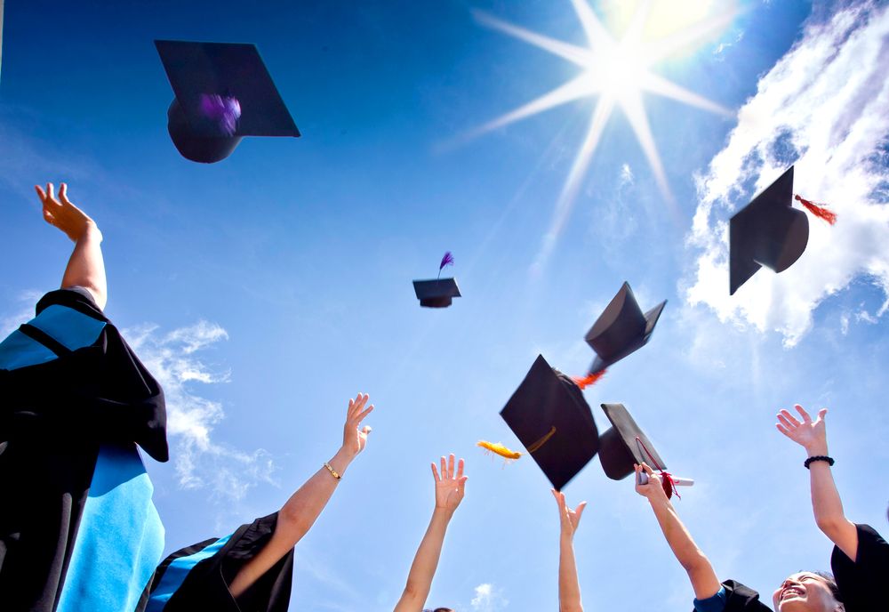 students throwing graduation caps in the air