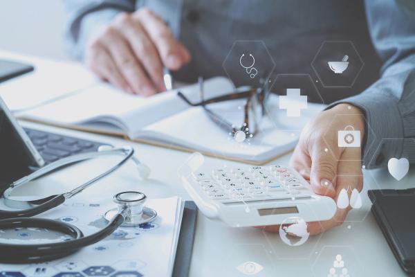 Hand of doctor using a calculator for medical costs in modern hospital | Image credit: everythingpossible - stock.adobe.com