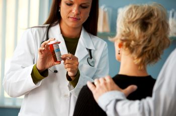 Physician showing prescription to patient and caregiver.
