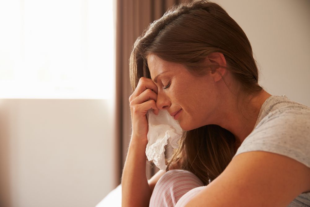 woman crying into tissue