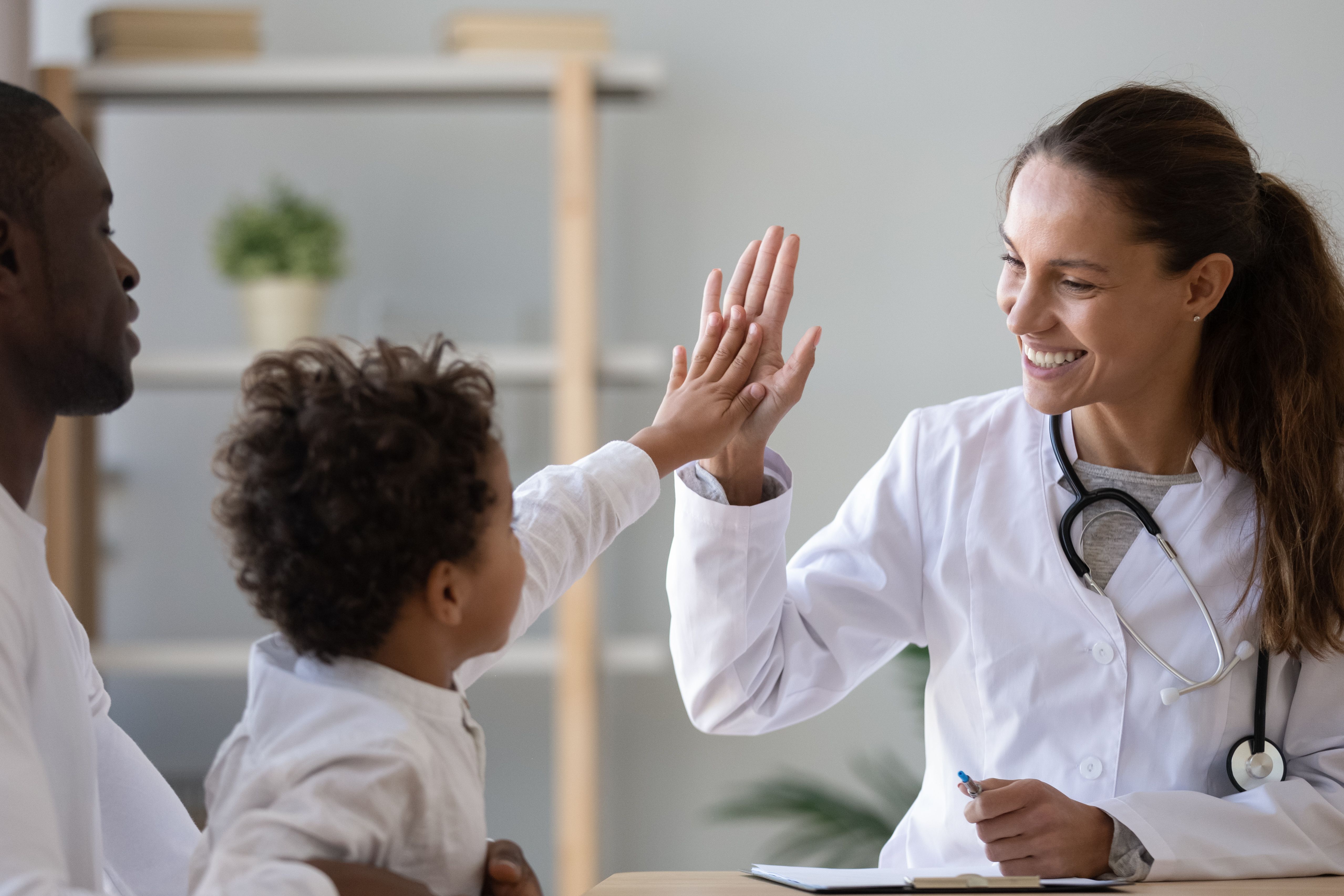 Black child high-fiving doctor | Image Credit: fizkes - stock.adobe.com