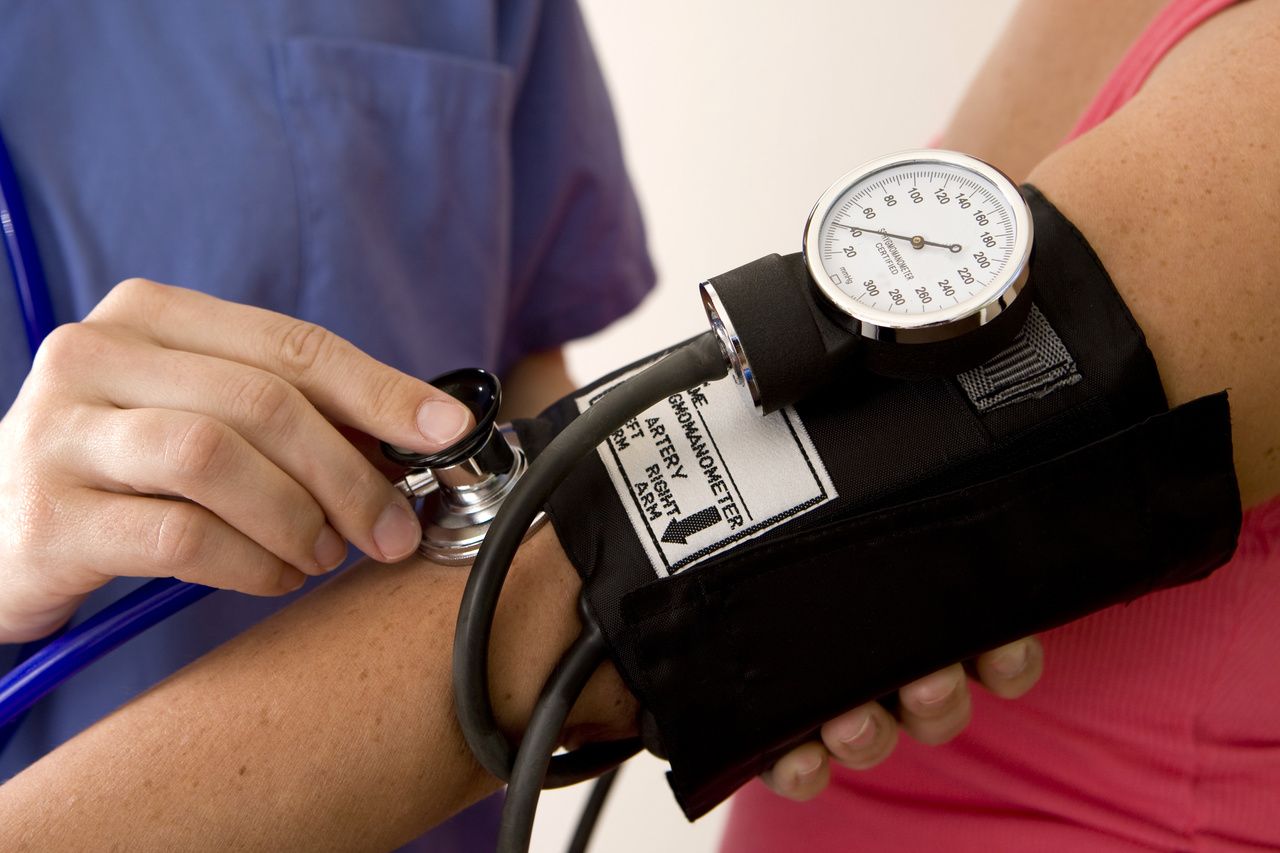 physician taking patient's blood pressure