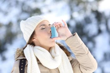 Woman using inhaler in winter outside | Image credit: Antonioguillem – stock.adobe.com