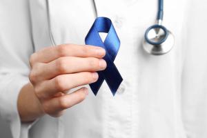 Doctor holding dark blue ribbon | Image Credit: New Africa - stock.adobe.com
