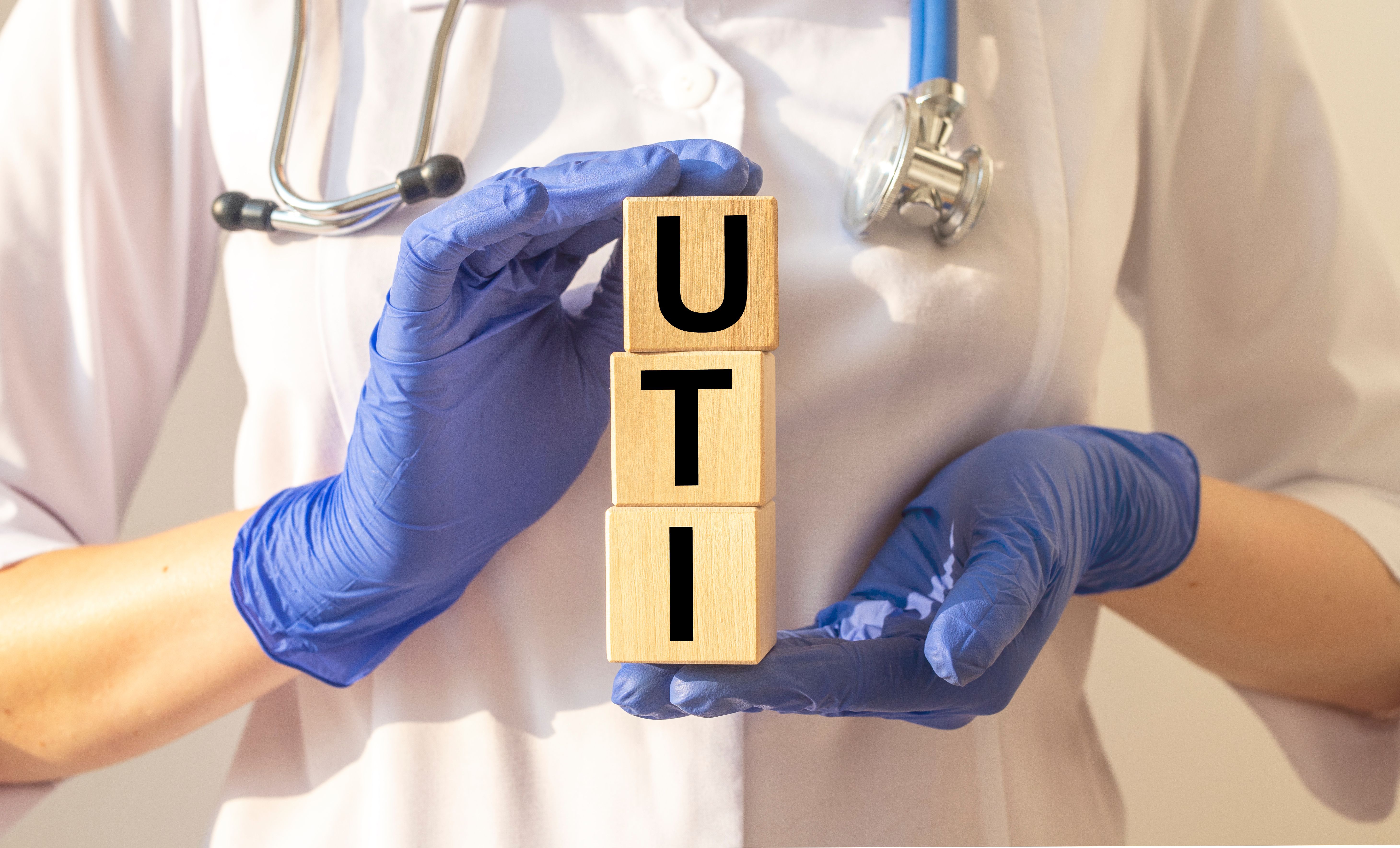 Doctor holding blocks that spell "UTI" | Image Credit: valiantsin - stock.adobe.com 