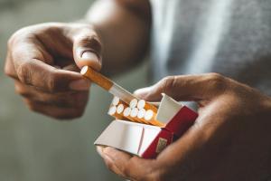 Hands holding pack of cigarettes | Image credit: Nopphon – stock.adobe.com