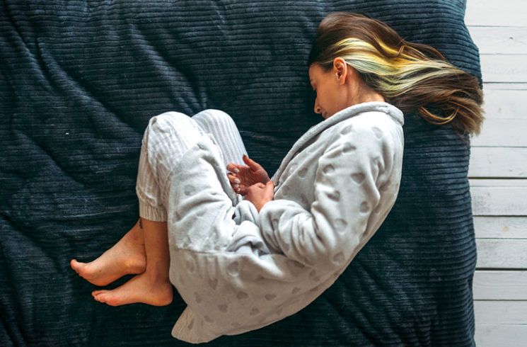 a woman is lying down in the fetal position