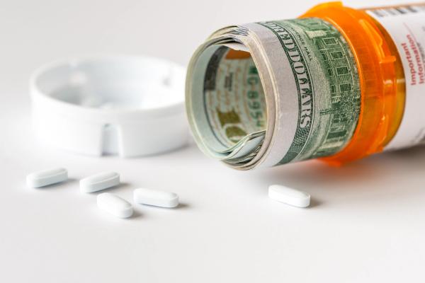Money rolled inside a prescription pill bottle | Image Credit: Kenishirotie - stock.adobe.com