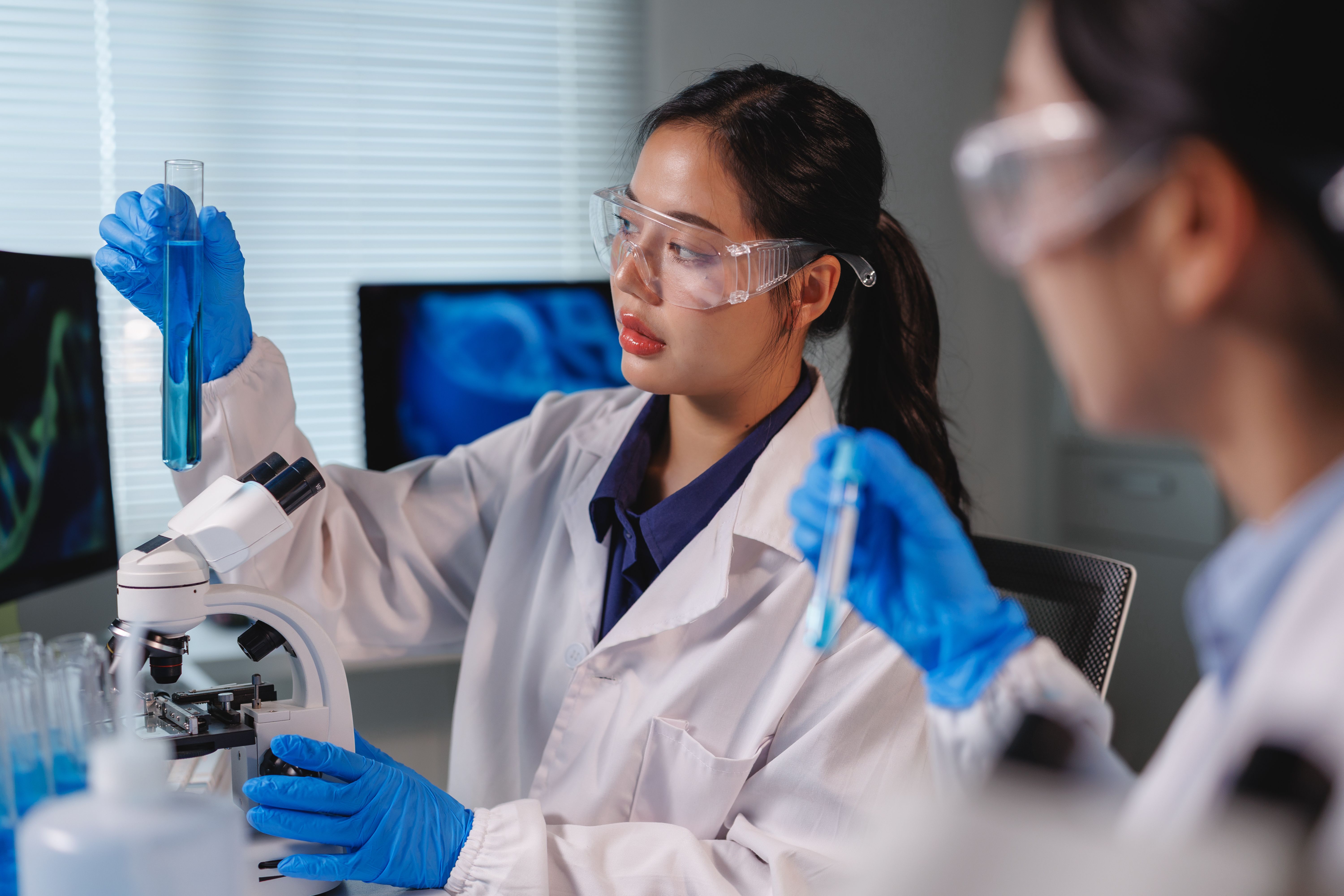 Scientists analyzing blue chemical liquid in test tube in laboratory | Image credit: Phimwilai - stock.adobe.com