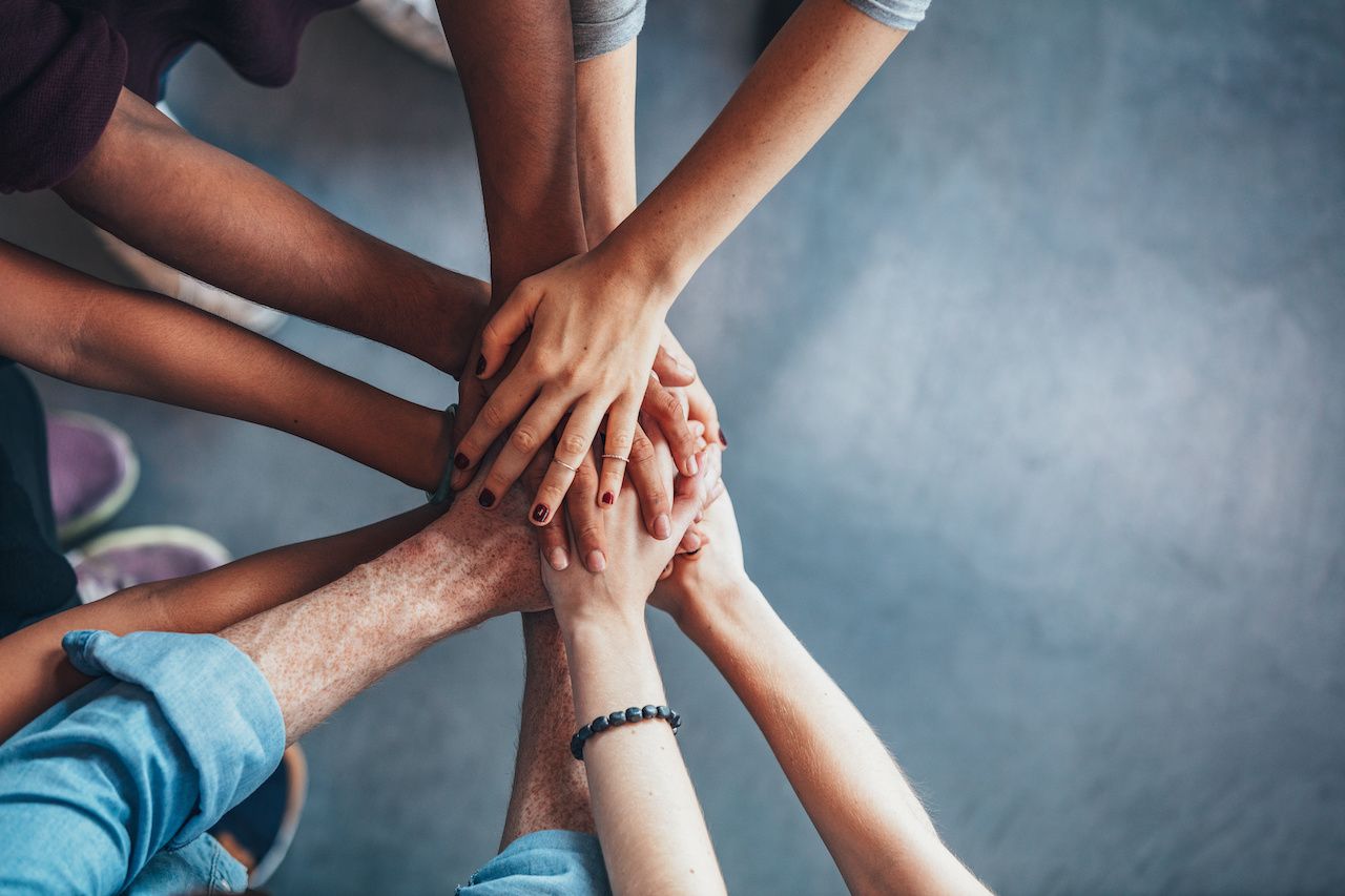 Stack of hands showing unity and teamwork: © Jacob Lund - stock.adobe.com