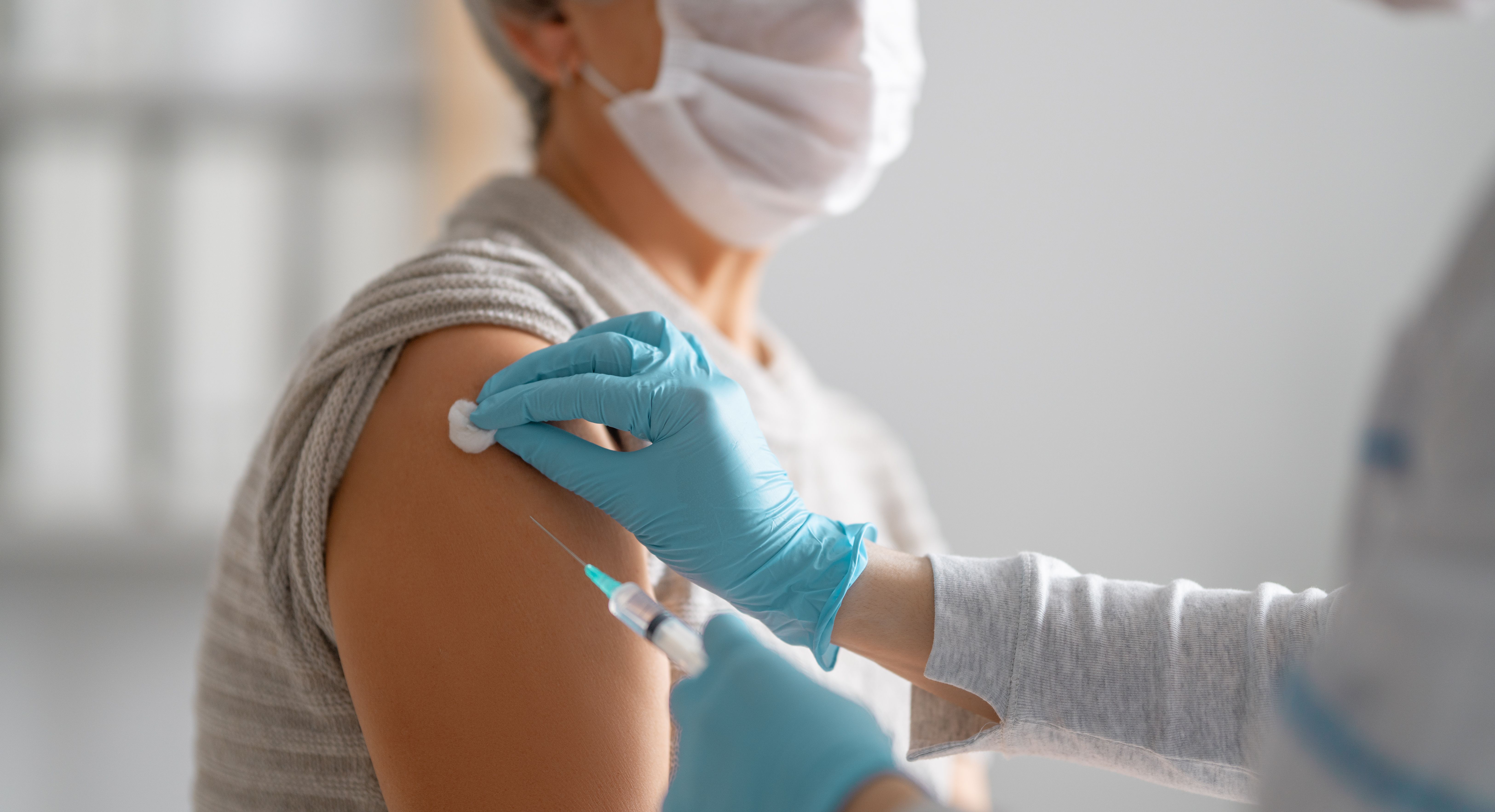 doctor administering a patient's vaccine